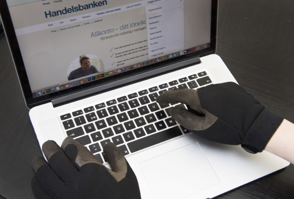 Bedrägeriförsök - en man sitter vid en dator och försöker komma åt inloggningsuppgifter till bank.
