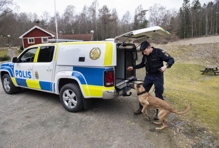 Polis släpper in hund i hundfordon.